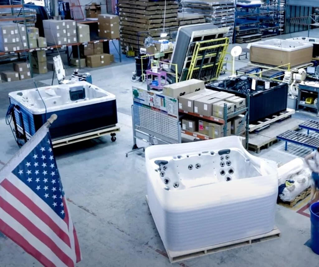 Vita Spa hot tubs being built on the factory floor, with an American flag in the foreground
