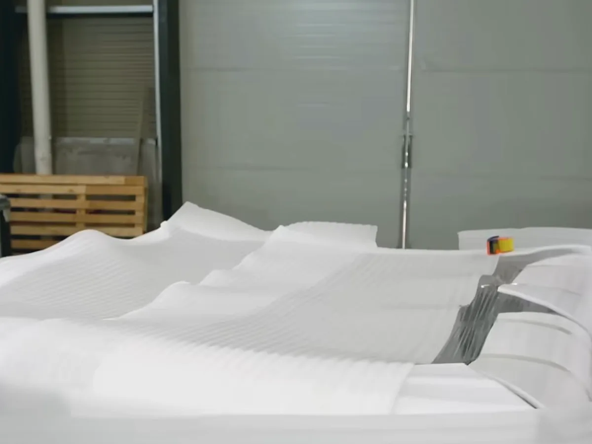 A grey acrylic hot tub shell on the Platinum Spas factory floor during quality control